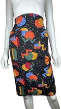 Load image into Gallery viewer, This size small Lularo Shape Skirt features a vibrant geometric print that stretches to fit larger sizes as well (bonus!). When measured flat, it boasts a 28&quot; waist, 34&quot; hips, and is 24&quot; in length. Get ready to turn heads with this playful and versatil...