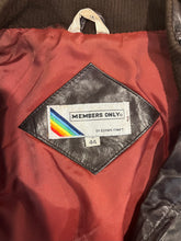 Load image into Gallery viewer, In perfect condition, this Vintage Brown Leather Members Only jacket is a rare find! The zip-up bomber jacket features a unique shoulder collar strap and has chest, sleeve, and length measurements of 40&quot;, 26&quot;, and 28&quot; when laid flat. Don&#39;t miss out on...