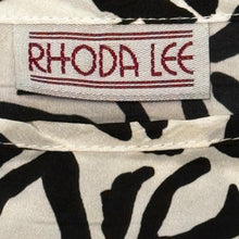 Load image into Gallery viewer, A vintage black and white all over floral print shirt by Rhoda Lee. Measured Flat Chest - 48&quot; Waist - 44&quot; Length - 22&quot;