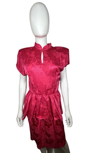 An 80’s vintage bright pink peplum dress with floral print on the silk. Measured Flat Chest- 32” Waist- 26” Hips- 36” Length- 41”