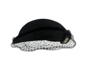 This pillbox hat is a vintage gem, featuring a black velvet design and adorned with a silver and rhinestone brooch. It's Union made and comes in its original box.