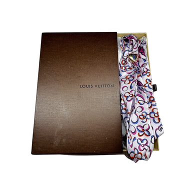 Add a touch of luxury to any outfit with this authentic Louis Vuitton floral silk scarf. The beautiful design and signature gold tie ring make it a versatile accessory for any occasion. Upgrade your style with a touch of French elegance!