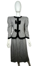 Load image into Gallery viewer, This posh Vintage Jessica Howard by Mitchell Rodbell suit features a charming houndstooth blazer with shoulder pads and a matching skirt. Measurements when laid out flat include 32&quot; for the top chest and 21&quot; for the sleeves, with a length of 23&quot;. The bottom waist measures 26&quot; and the hips are a generous 44&quot; with a length of 31&quot;.
