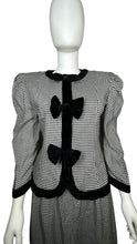 Load image into Gallery viewer, This posh Vintage Jessica Howard by Mitchell Rodbell suit features a charming houndstooth blazer with shoulder pads and a matching skirt. Measurements when laid out flat include 32&quot; for the top chest and 21&quot; for the sleeves, with a length of 23&quot;. The bottom waist measures 26&quot; and the hips are a generous 44&quot; with a length of 31&quot;.