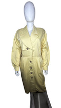 Load image into Gallery viewer, This vintage yellow trench dress can do double duty as both a dress and an open trench coat. One of the buttons is currently M.I.A. at the very bottom, but it&#39;s still a standout piece. When lying flat, it measures 22 inches for the sleeve, 32 inches fo...