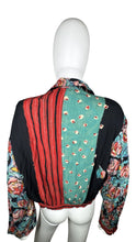 Load image into Gallery viewer, This Vintage Carole Little blouse is adorned with charming rose buttons and features a playful tie front. Measurements include a 34&quot; chest, 23&quot; sleeves, and a length of 19 1/2&quot;.