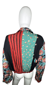 This Vintage Carole Little blouse is adorned with charming rose buttons and features a playful tie front. Measurements include a 34" chest, 23" sleeves, and a length of 19 1/2".