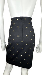 This is a Vintage Outlander Collection Skirt from the 80's thats a high waisted black skirt with metal gold studs all over that zips in the back. Measured Flat Waist - 28" Hips - 36" Length - 21"