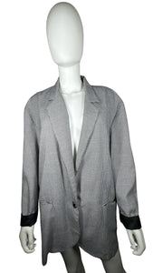 Experience the timeless style and sophistication of the Vintage Marnie Houndstooth 80s Blazer. This stunning black and white blazer features two front pockets, a single front button, and stylish black cuffs on the sleeves. With a measured flat chest of...