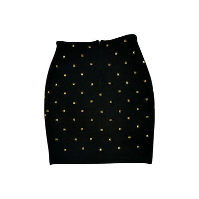 This is a Vintage Outlander Collection Skirt from the 80's thats a high waisted black skirt with metal gold studs all over that zips in the back. Measured Flat Waist - 28
