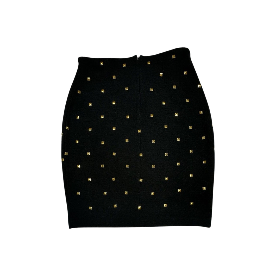 This is a Vintage Outlander Collection Skirt from the 80's thats a high waisted black skirt with metal gold studs all over that zips in the back. Measured Flat Waist - 28