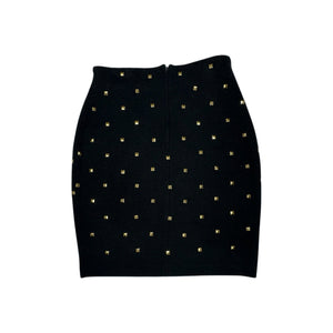 This is a Vintage Outlander Collection Skirt from the 80's thats a high waisted black skirt with metal gold studs all over that zips in the back. Measured Flat Waist - 28" Hips - 36" Length - 21"