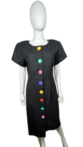 The Vintage 80's Rare Find David Mitchell Dress boasts a black hue and bold, vibrant oversized buttons. With measurements of Chest - 35", Hips - 34", and Length - 43", this dress offers a fun and unique twist to the classic little black dress.