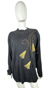Experience the ultimate blend of style and comfort with our Vintage AfterShock Sweatshirt. This black long sleeve has been beautifully crafted with gold embellishment, embroidered tassels, and shoulder pads. Measured at 46" for the chest, 25" for the s...