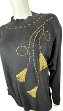 Load image into Gallery viewer, Experience the ultimate blend of style and comfort with our Vintage AfterShock Sweatshirt. This black long sleeve has been beautifully crafted with gold embellishment, embroidered tassels, and shoulder pads. Measured at 46&quot; for the chest, 25&quot; for the s...