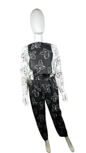 Load image into Gallery viewer, Introducing a one-of-a-kind black and white floral jumpsuit from the 80&#39;s, complete with a stretch waist for ultimate comfort. Measurements include: Chest - 39&quot;, Sleeve - 24&quot;, Waist - 26&quot;, Hips - 40&quot;, Inseam - 28&quot;, Length - 60&quot;. Don&#39;t miss this rare vi...