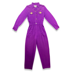This rare find Vintage 80's Saint Germain Jumpsuit is a vintage purple button up jumpsuit with gold stitching and embellishing with a stretch waist. Measured Flat Sleeve - 24" Waist - 26" Hips - 36" Length - 58"