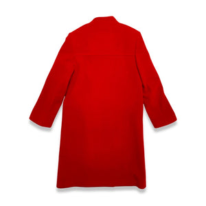 The Vintage KronHaus Coat is a luxurious, bespoke red wool coat. Its unique vintage charm is further enhanced by subtle imperfections near the button zipper area, as shown in the picture. 